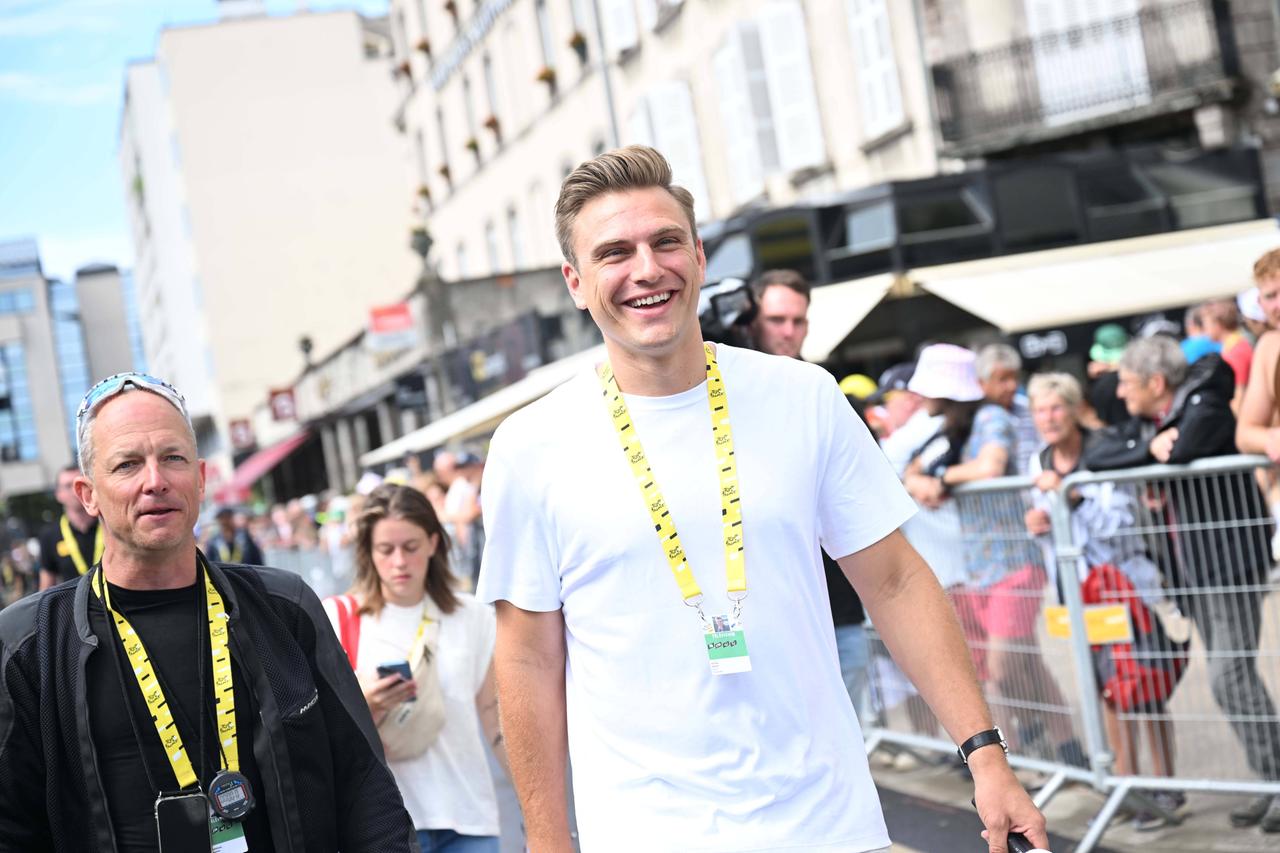 Marcel Kittel am Rande der Tour de France 2024. Er trägt ein weißes T-Shirt und einen Kragen mit offizieller Akkreditierung.