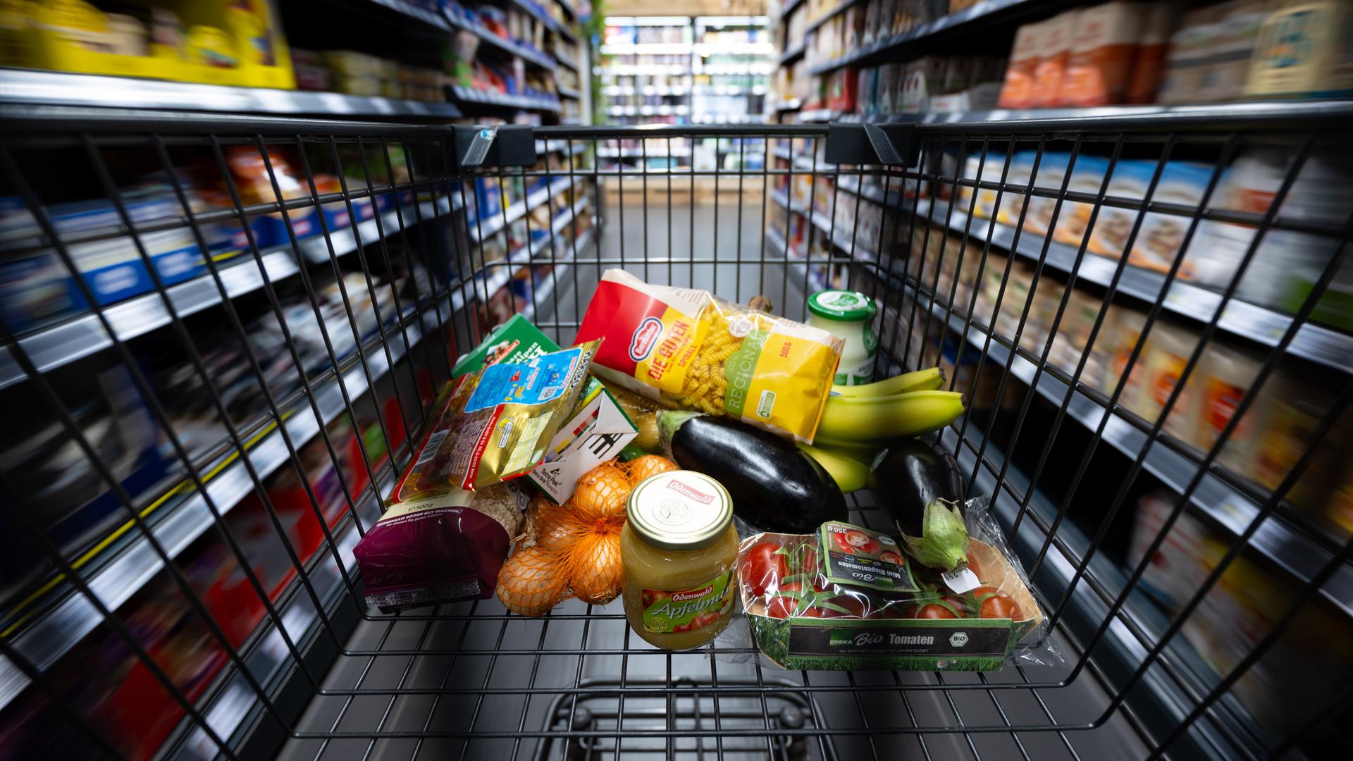 Verschiedene Lebensmittel liegen in einem Supermarkt in einem Einkaufswagen