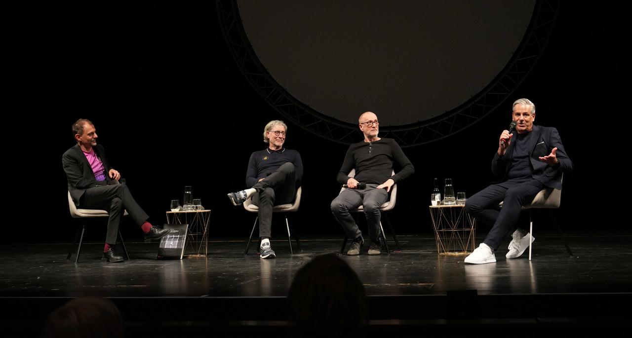 Olaf Kröck, Harald "Toni" Schumacher, Peter Lohmeyer und Manuel Neukirchner (v.l.) sitzen auf der Theaterbühne beim Stück "Die Nacht von Sevilla".