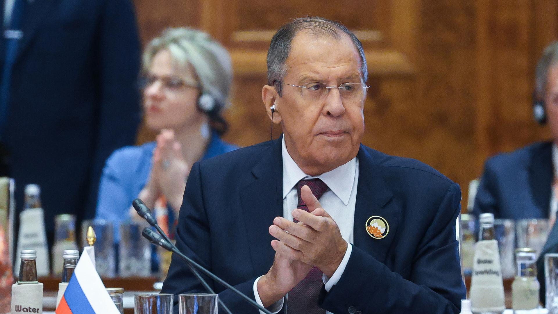 Der russische Außenminister Sergej Lawrow sitzt an seinem Platz im Konferenzsaal und klatscht. Der russische Außenminister Sergej Lawrow sitzt an seinem Platz im Konferenzsaal und klatscht.