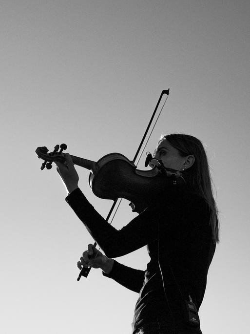 Ein Schwarz-Weiß-Foto zeigt eine Violinistin beim Musizieren.