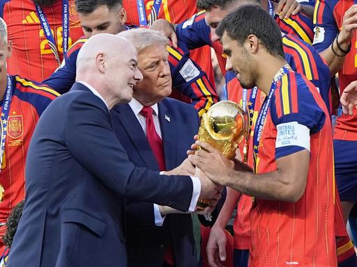 US-Präsident Donald Trump (Mitte) und FIFA-Präsident Gianni Infantino (links) überreichen Rodri (rechts), dem Kapitän der Spanier, nach dem 1:0-Sieg über Argentinien im New Jersey Stadium in East Rutherford, New Jersey, den goldenen Siegerpokal. US-Präsident Donald Trump (Mitte) und FIFA-Präsident Gianni Infantino (links) überreichen Rodri (rechts), dem Kapitän der Spanier, nach dem 1:0-Sieg über Argentinien im New Jersey Stadium in East Rutherford, New Jersey, den goldenen Siegerpokal.