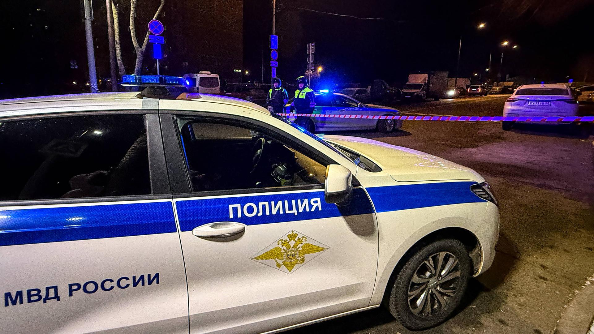 Ein Polizeiauto steht quer auf der Straße. Dahinter ist eine Absperrung zu erkennen.