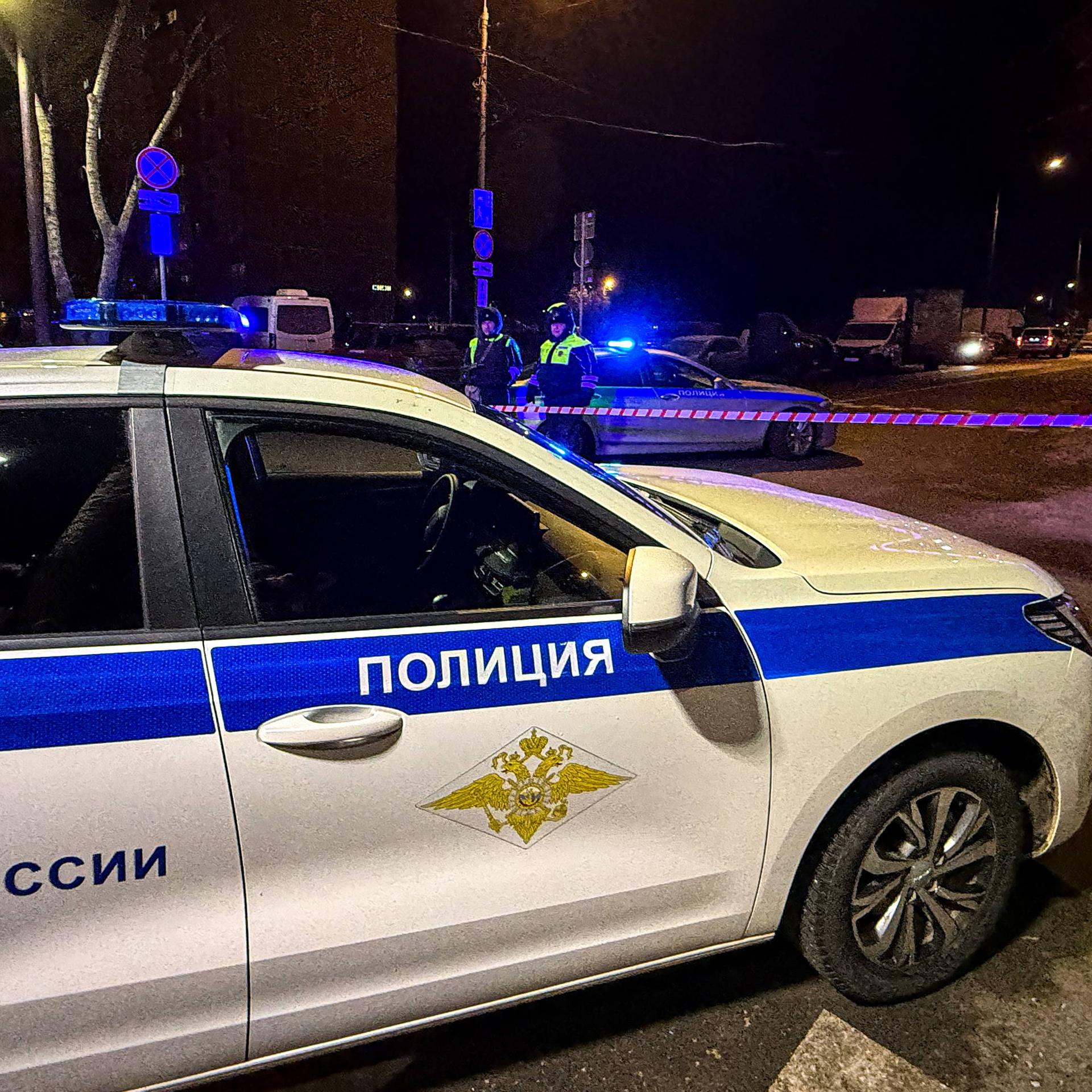 Ein Polizeiauto steht quer auf der Straße. Dahinter ist eine Absperrung zu erkennen.