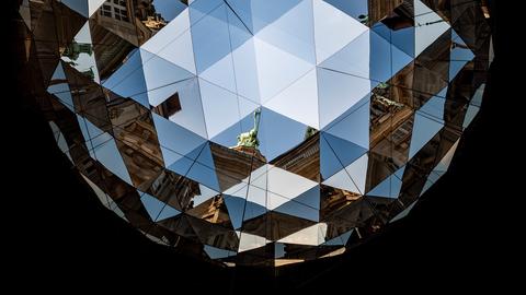 Blick in ein Kaleidoskop, Elemente der umliegenden Häuser und des Rathauses in Hamburg sind zu sehen. 