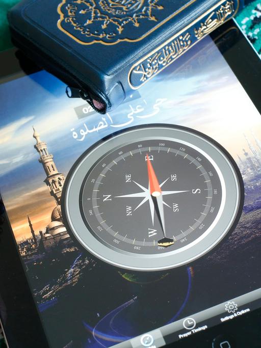 Eine islamische Kompass-App zeigt auf einem Tablet an, in welcher Richtung Mekka liegt.