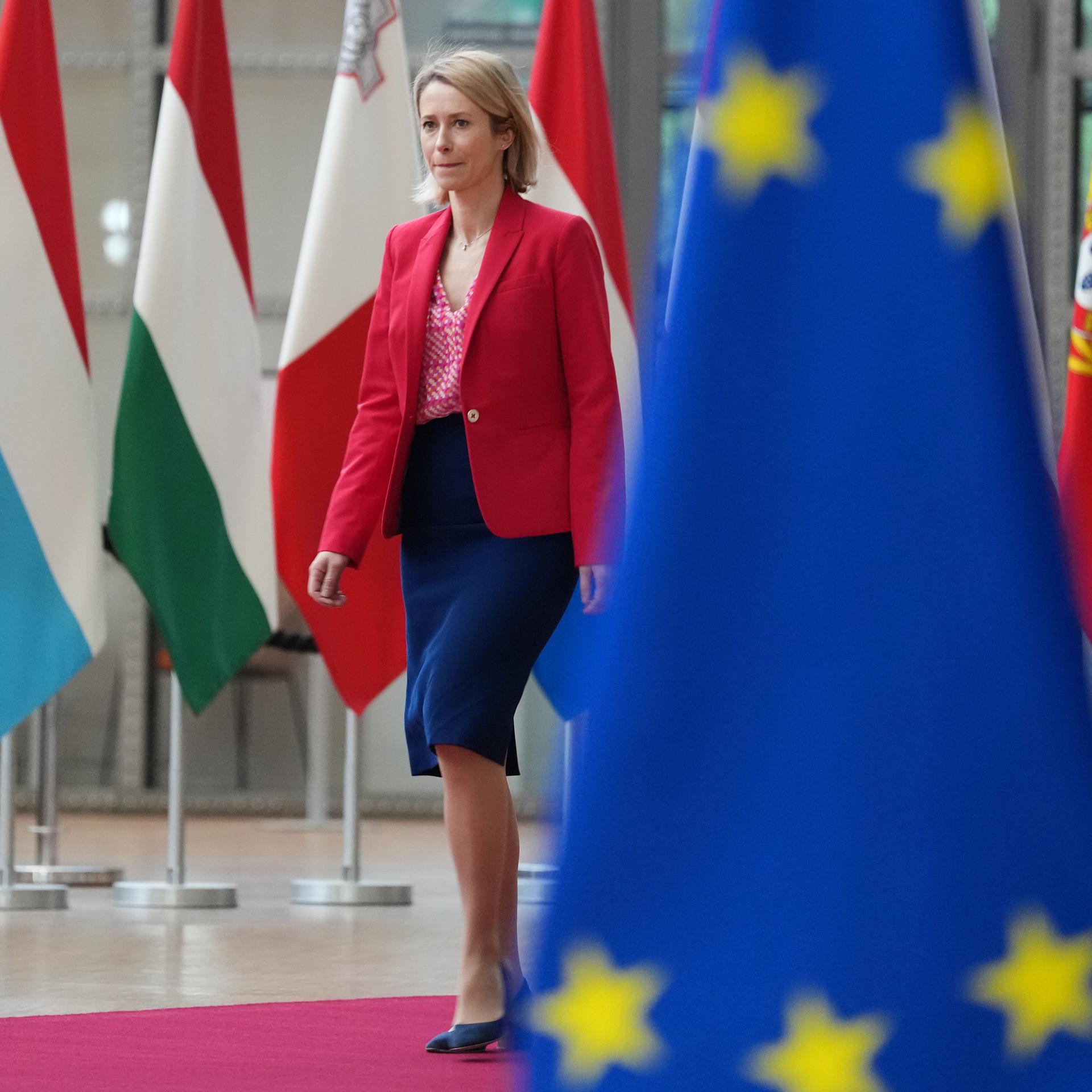 Die EU-Außenbeauftragte Kaja Kallas geht vor den Flaggen der Mitgliedsländer im Gebäude des Europäischen Rates in Brüssel.