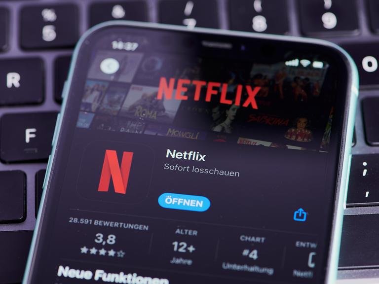 Ein Smartphone, auf dem ein Netflix-Account per App geöffnet wird.