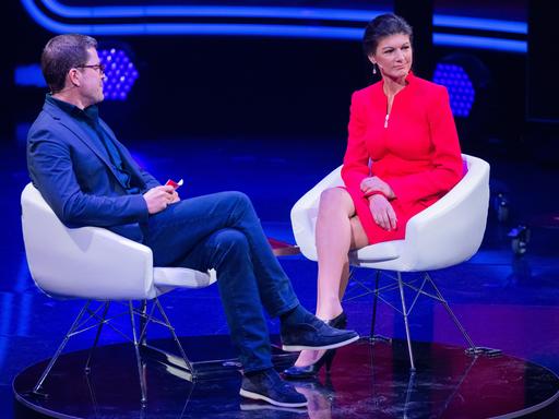Karl-Theodor zu Guttenberg, Moderator, und Sahra Wagenknecht (Die Linke), sitzen beim RTL-Jahresrückblick "Menschen, Bilder, Emotionen 2022" im Studio.