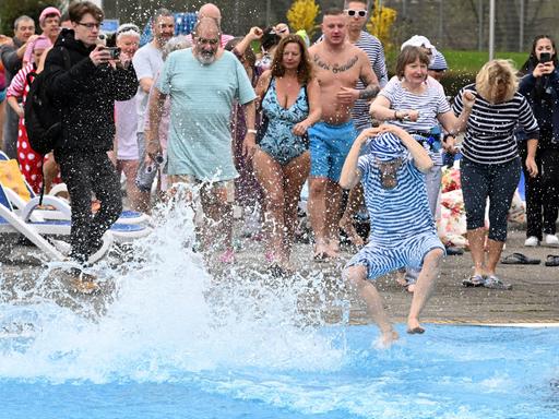 Unerschrockende Schwimmer bei der Eröffnung eines Freibads im März