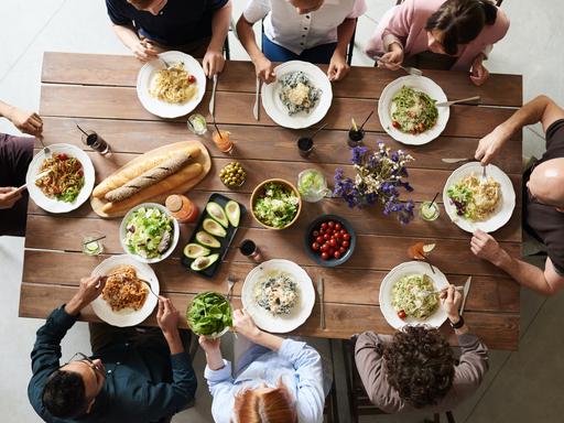 Eine Gruppe sitzt zusammen an einem Tisch und isst. 