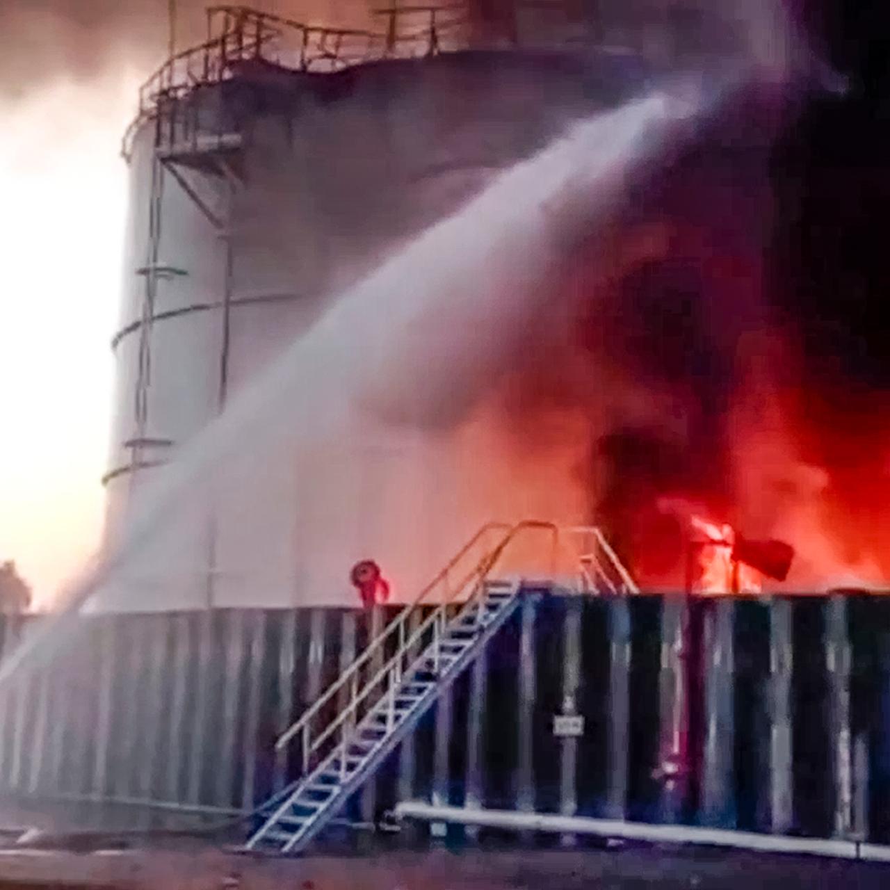 Auf diesem vom Pressedienst des russischen Katastrophenschutzministeriums veröffentlichten Foto arbeiten Feuerwehrleute an der Brandstelle eines Ölreservoirs im Bezirk Asow.  