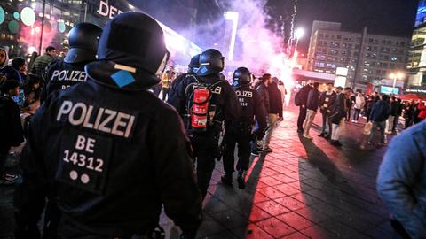 Polizisten rennen in der Silvesternacht auf den Alexanderplatz in Berlin, wo trotz Verbots ein Feuerwerk gezündet wurde.