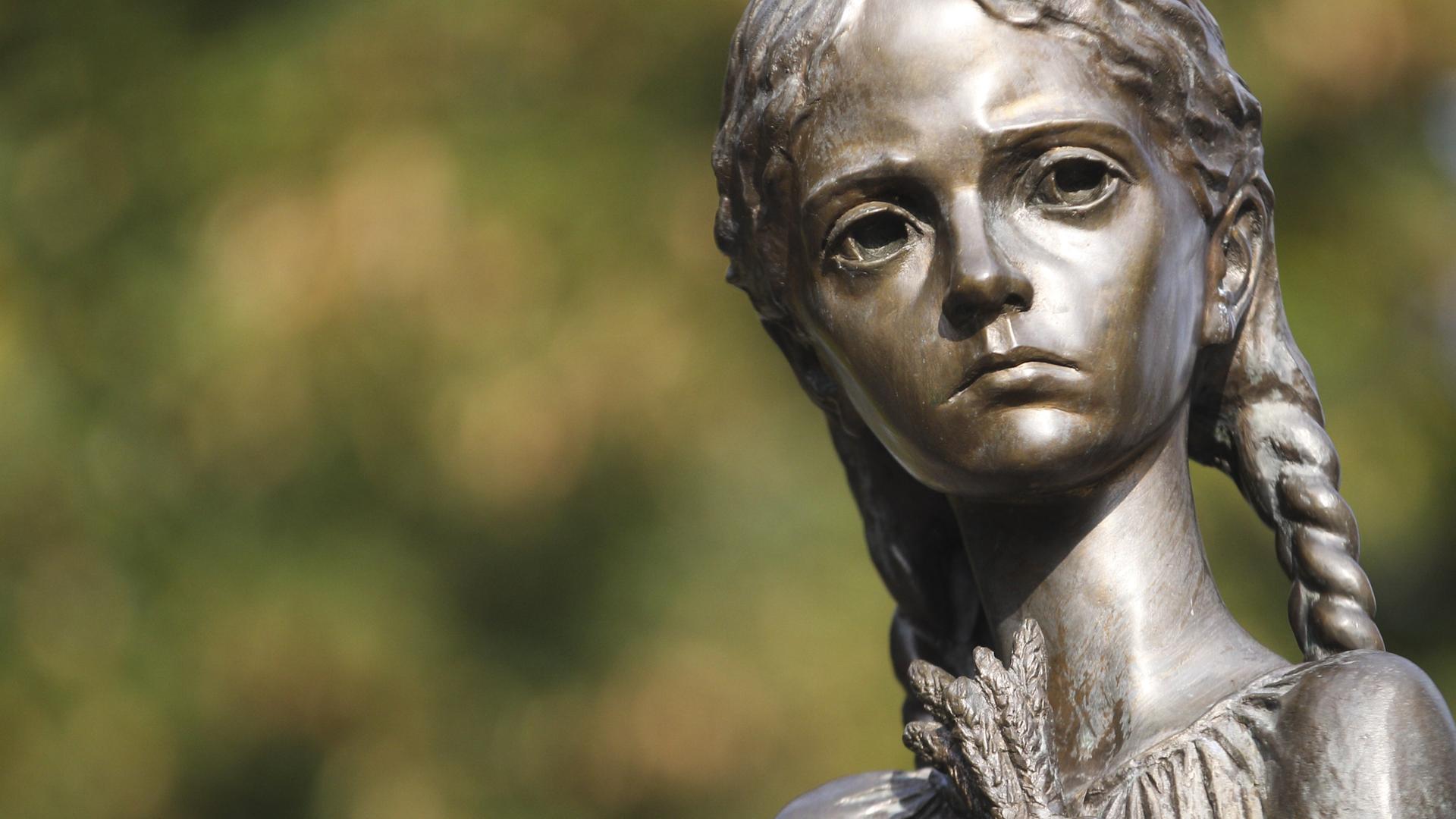 Das Bild zeigt die Statue eines Mädchen mit traurigem Blick und ausgezehrtem Gesicht, in der Hand einige Getreidehalme, aus dem ukrainischen Nationalmuseums in Kiew zum Gedenken der Holodomor-Opfer