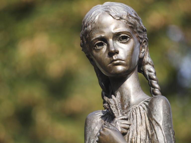 Das Bild zeigt die Statue eines Mädchen mit traurigem Blick und ausgezehrtem Gesicht, in der Hand einige Getreidehalme, aus dem ukrainischen Nationalmuseums in Kiew zum Gedenken der Holodomor-Opfer