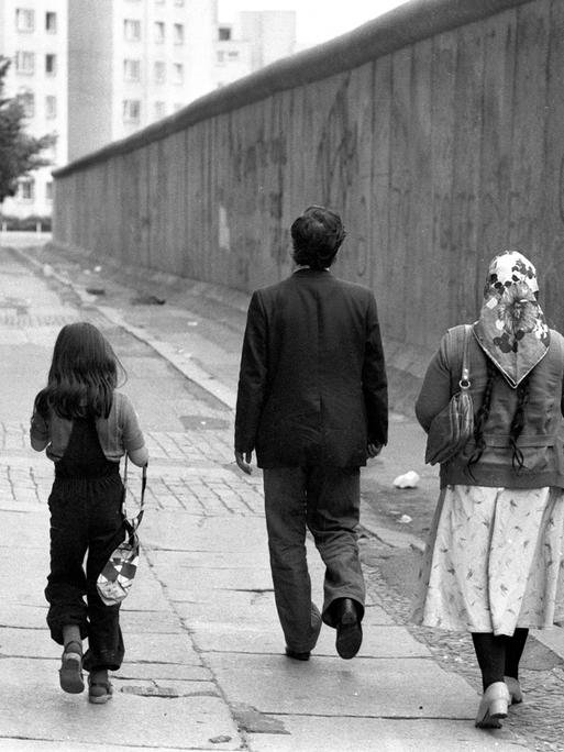 Eine türkische Familie geht entlang der Berliner Mauer spazieren.