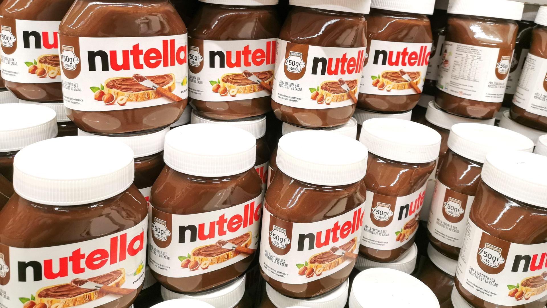 Viele Nutella-Gläser stehen aufeinandergestapelt. Viele Nutella-Gläser stehen aufeinandergestapelt.