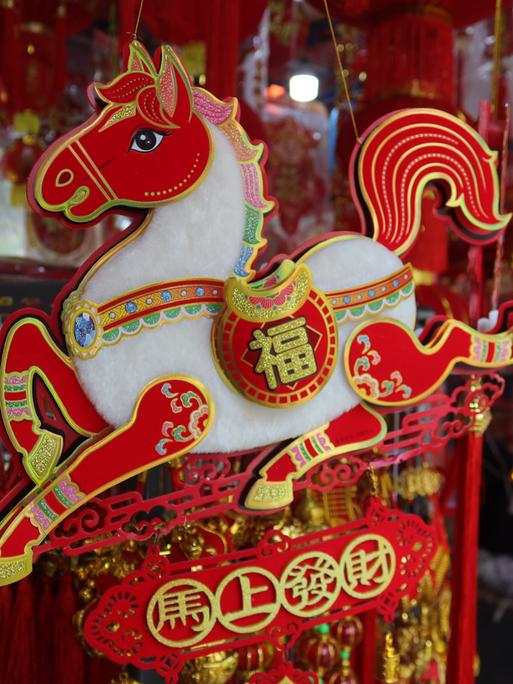 Eine chinesische Pferdefigur an einem Marktstand.