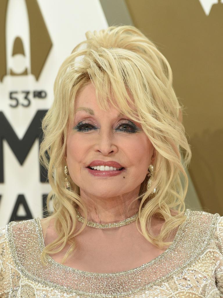 Dolly Parton am 13. November 2019, sie trägt ein gold-glitzerndes Oberteil und lächelt in die Kamera.