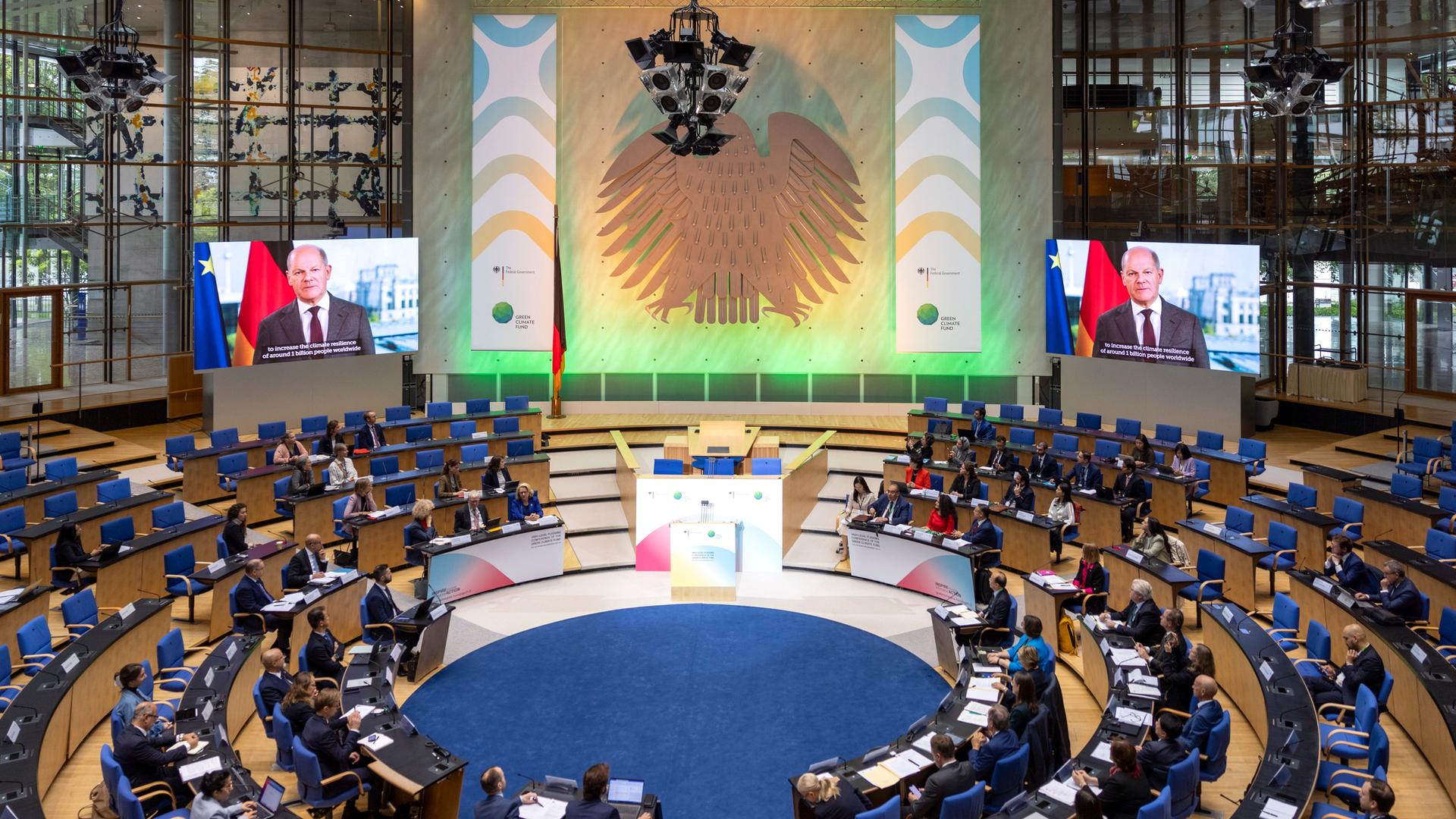 Blick in das Plenum des Bundeshauses in dem die internationale Wiederauffüllungskonferenz für den Grünen Klimafonds stattfindet, während der Video-Ansprache von Bundeskanzler Olaf Scholz. 