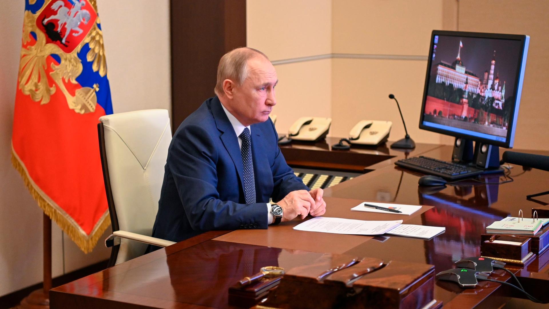 Russlands Präsident Putin sitzt vor einem Bildschirm an seinem Schreibtisch. Russlands Präsident Putin sitzt vor einem Bildschirm an seinem Schreibtisch.
