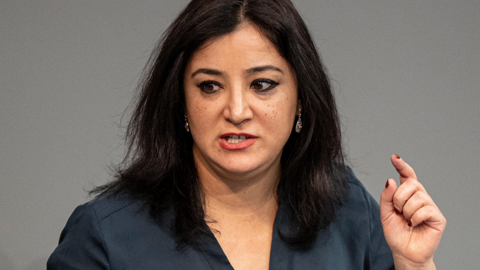 Gökay Akbulut, eine Frau mit langem schwarzem Haar, steht gestikulierend am Rednerpult des Bundestages. Gökay Akbulut, eine Frau mit langem schwarzem Haar, steht gestikulierend am Rednerpult des Bundestages.