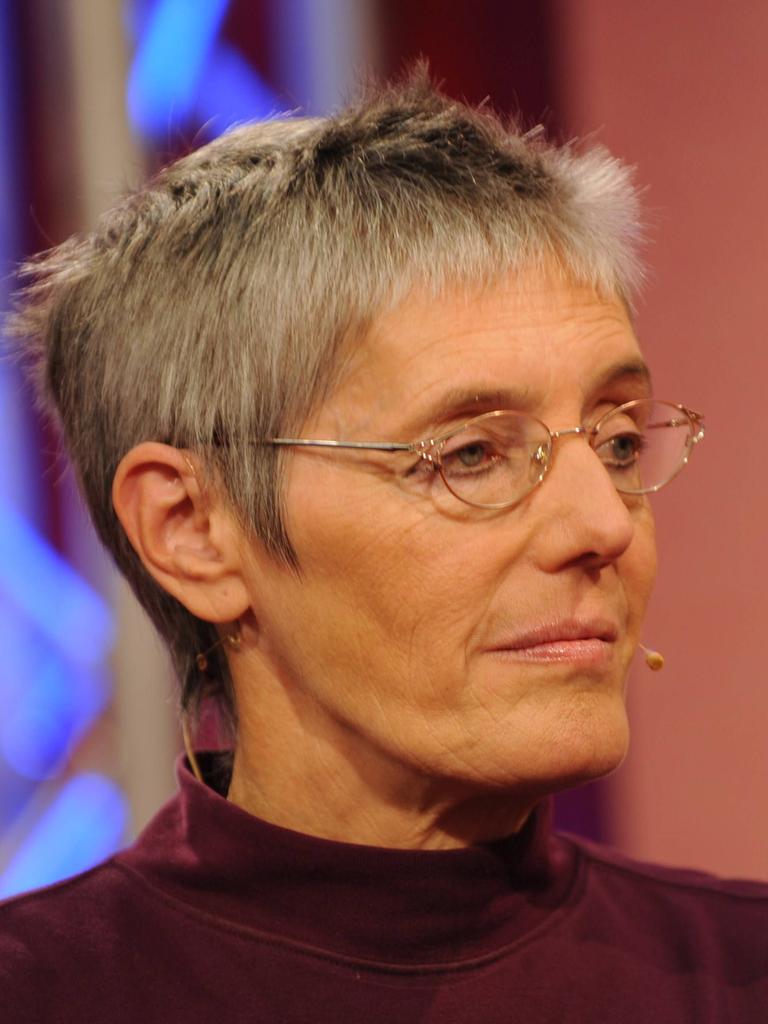 Petra Morsbach sitzt in einem Fernsehstudio und schaut zur Seite. Sie hat kurze Haare und trägt eine Brille.