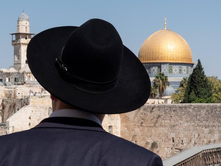 Ein orthodoxer Jude mit schwarzem Hut vor dem Felsendom in Jerusalem.