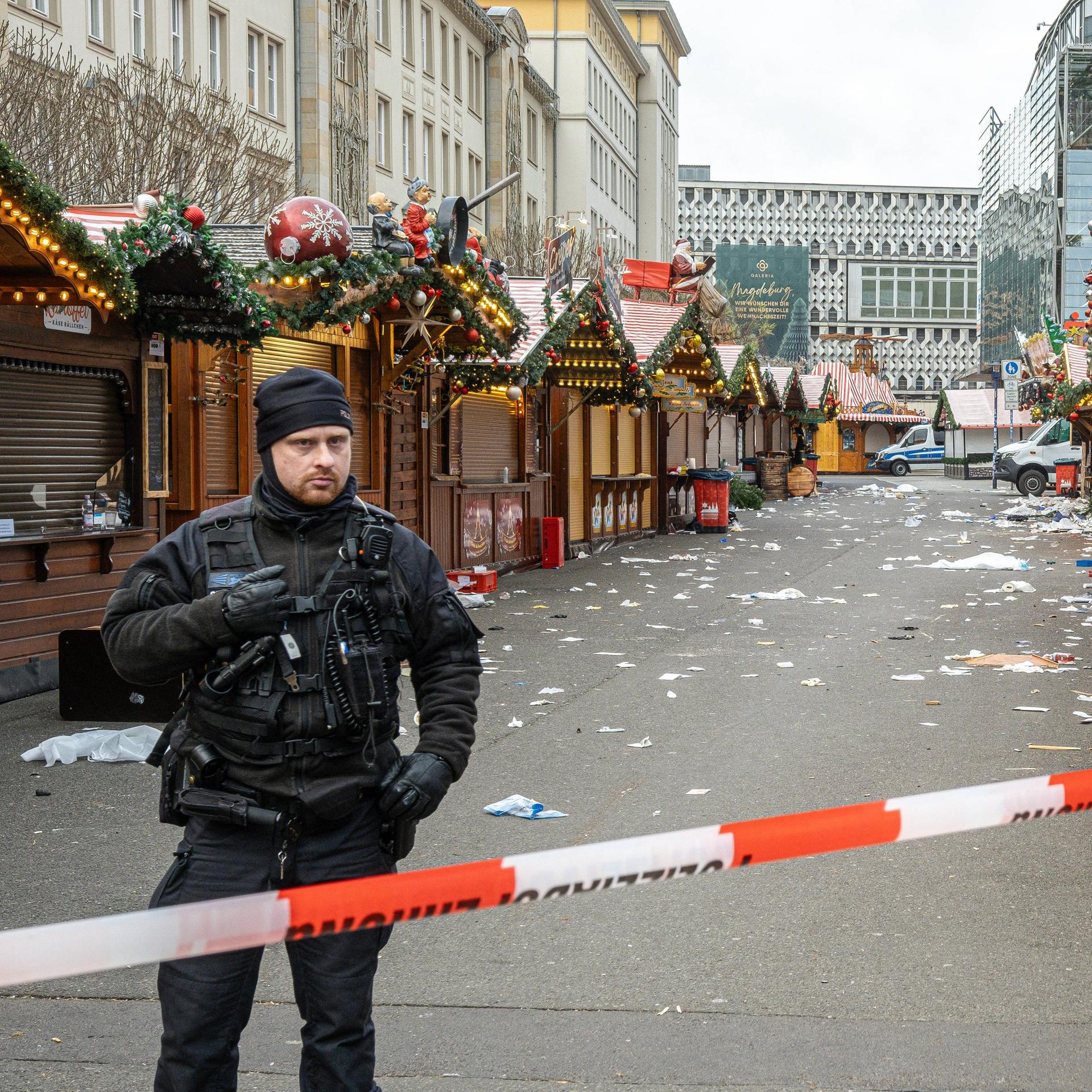 Polizisten stehen am Tag nach dem Anschlag hinter einem Absperrband vor dem Weihnachtsmarkt in Magdeburg.