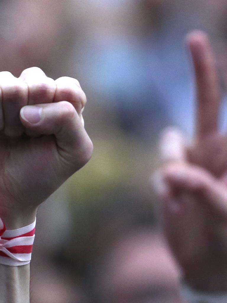 Ein Mensch streckt während einer Oppositionskundgebung im Jahr 2020 auf dem Unabhängigkeitsplatz in Minsk seine Faust in die Höhe. Er trägt ein weiß-rotes Armband, es sind die Farben der Opposition. Ein Mensch streckt während einer Oppositionskundgebung im Jahr 2020 auf dem Unabhängigkeitsplatz in Minsk seine Faust in die Höhe. Er trägt ein weiß-rotes Armband, es sind die Farben der Opposition.