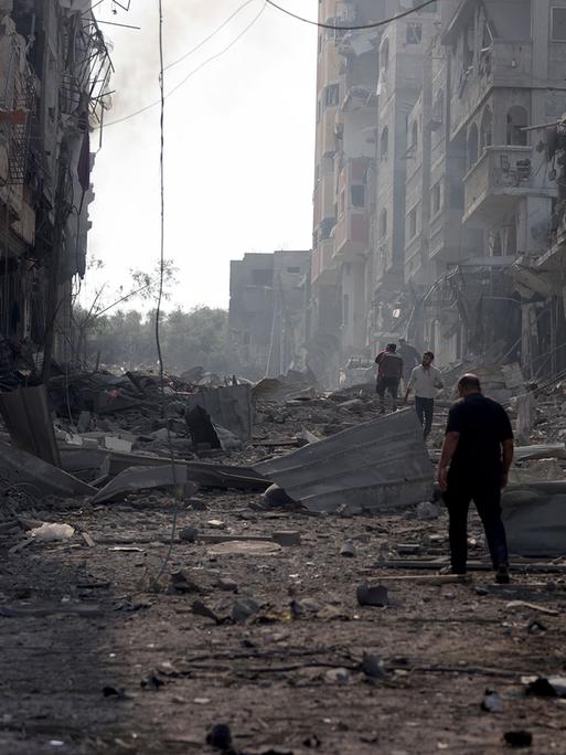 Nach einem israelischen Luftangriff,  sieht man am 11. Oktober 2023 in Gaza-Stadt Menschen zwischen zerstörte Gebäude und Trümmer im Stadtteil Jabalia. 