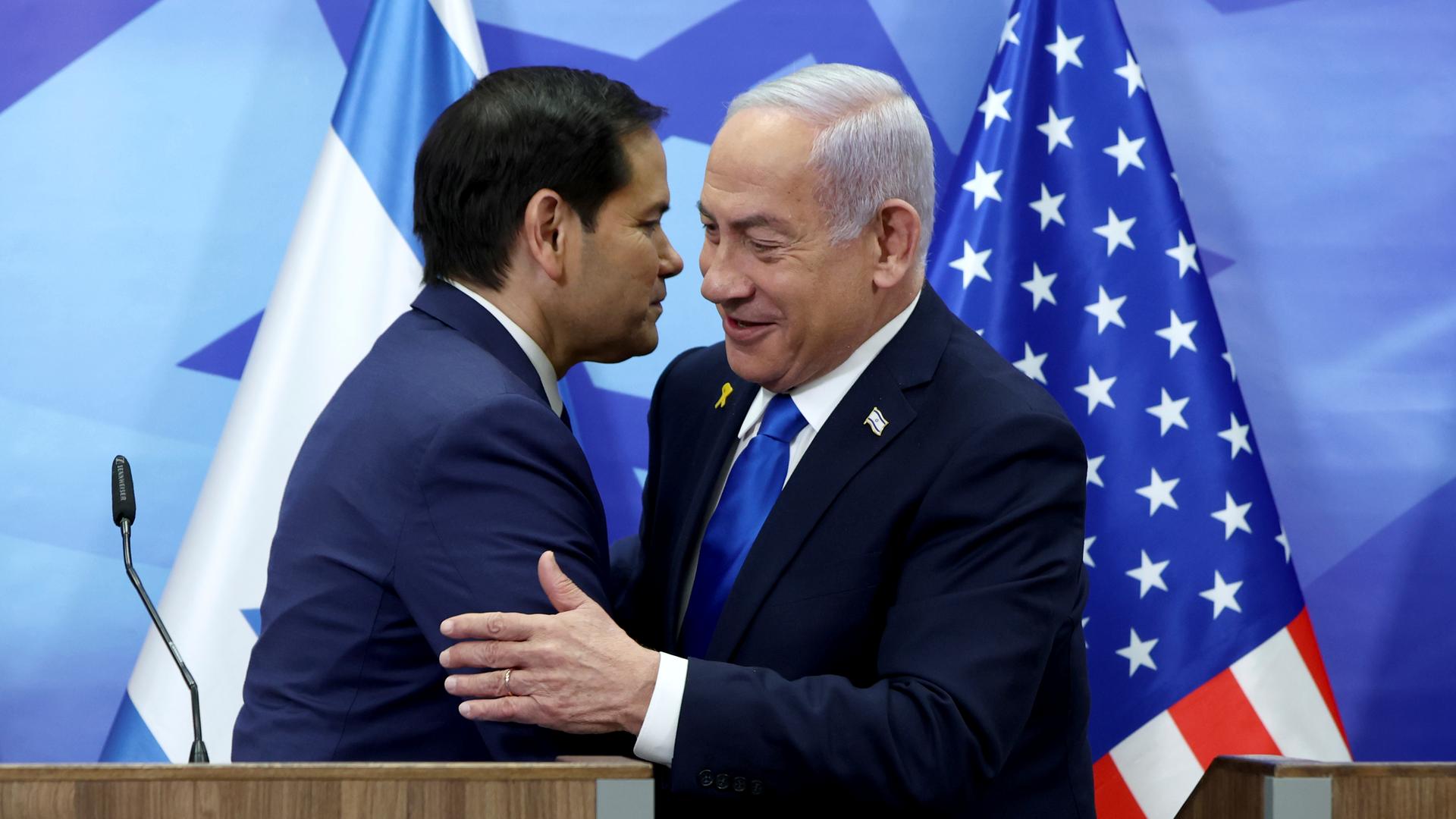 Das Bild zeigt die beiden Politiker Marco Rubio und Benjamin Netanjahu, die sich nach einer Pressekonferenz umarmen. 