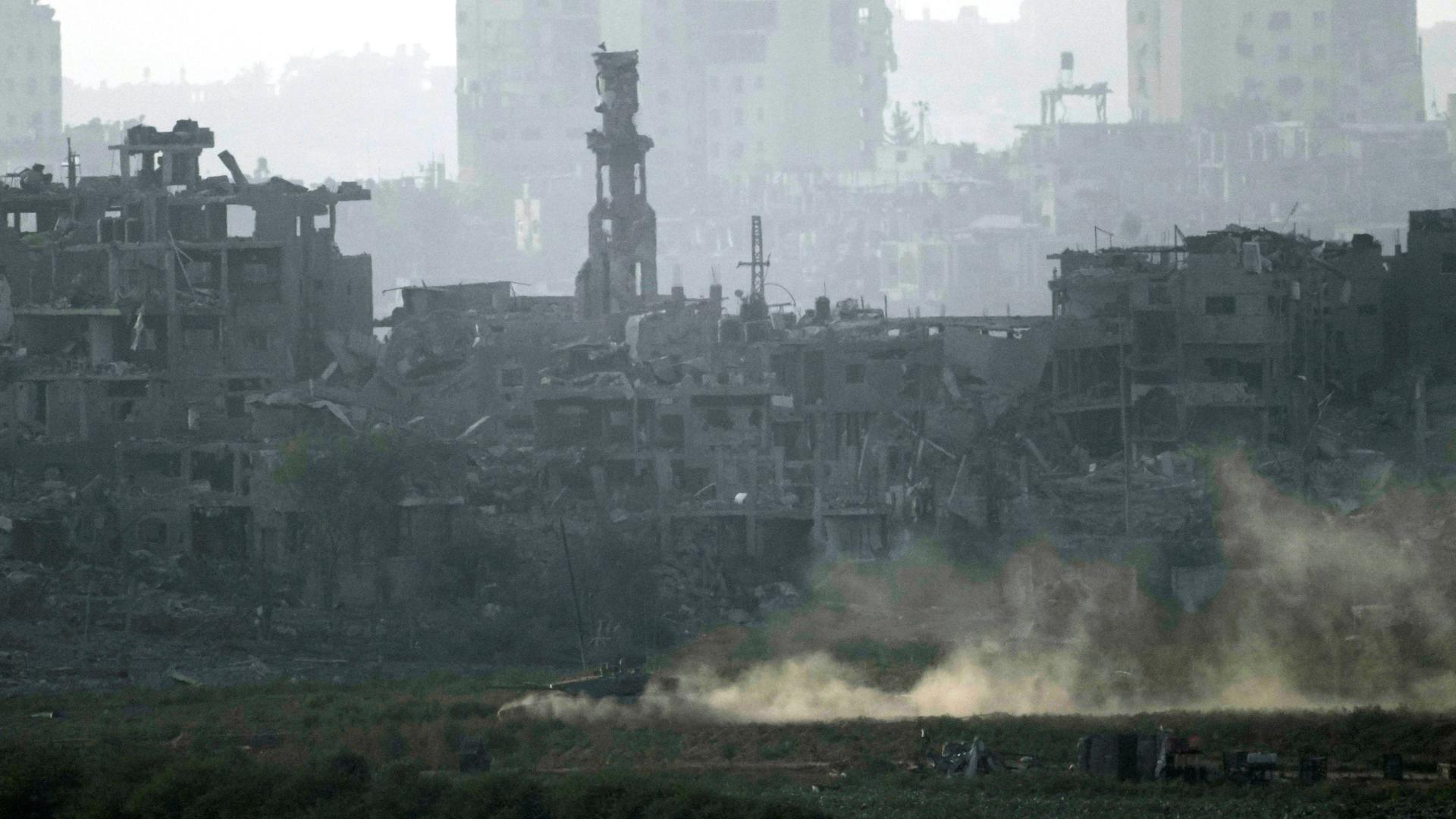 Ein israelischer Panzer fährt an einem zerstörten Haus im Gazastreifen vorbei. Ein israelischer Panzer fährt an einem zerstörten Haus im Gazastreifen vorbei.