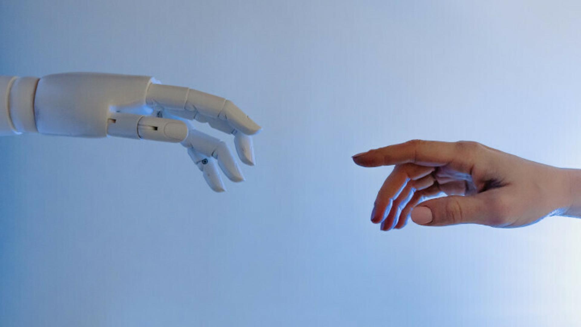Die Hand eines Roboters und eine menschliche Hand berühren sich fast.
