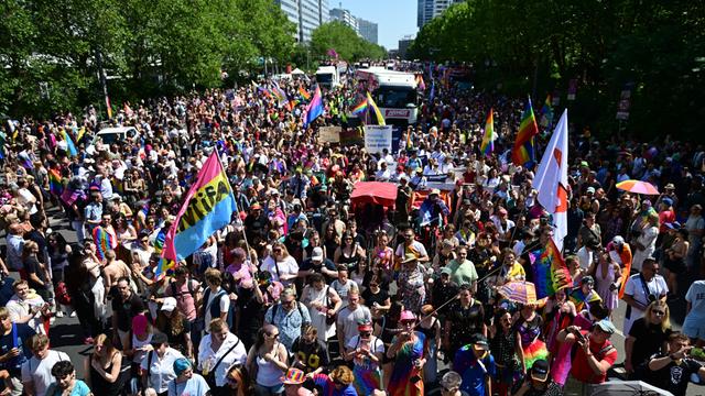 Eine große bunte Menschen-Menge auf einer Straße.