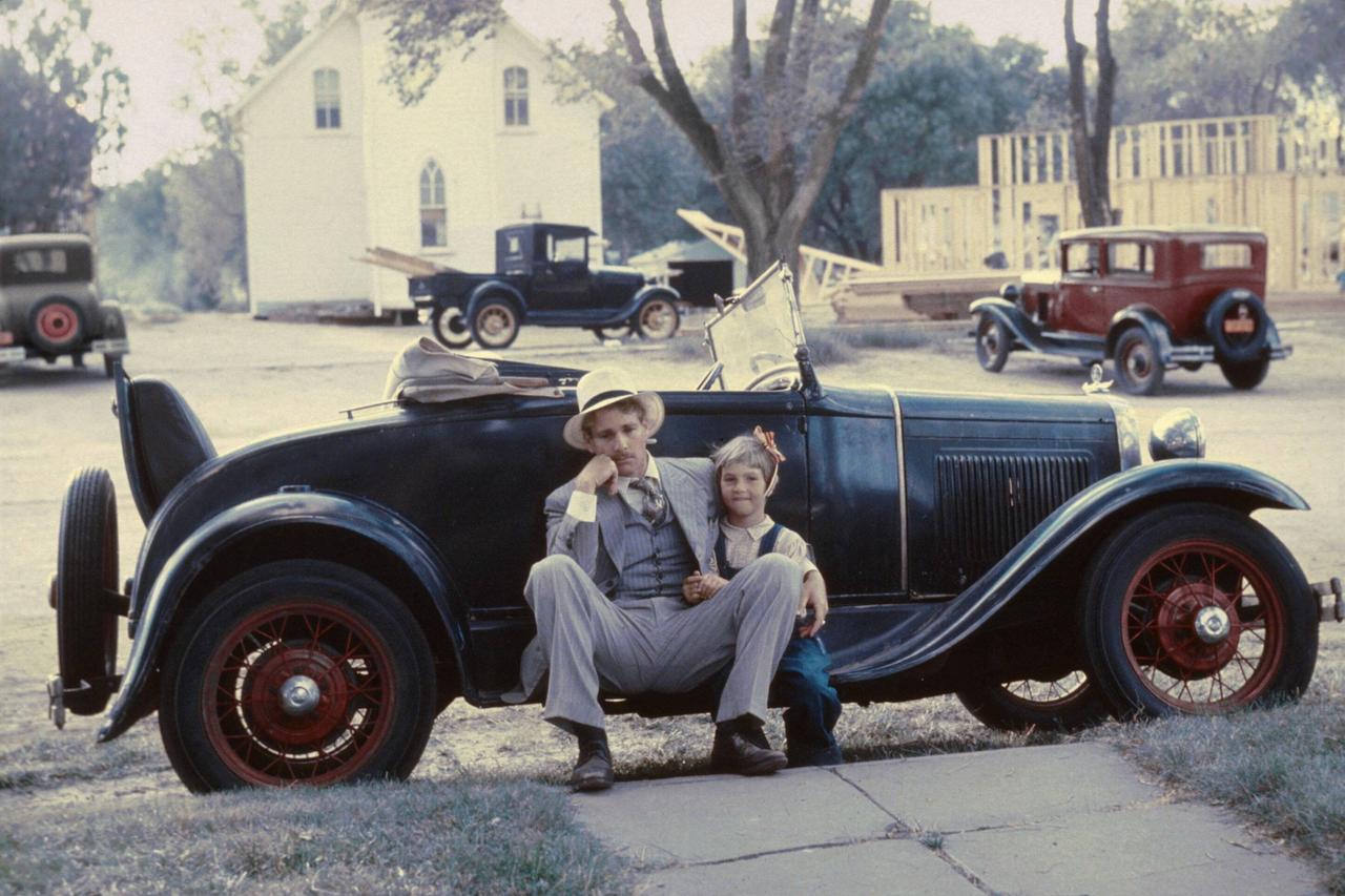 Die Schauspieler Ryan und Tatum O'Neal sitzen vor einem Auto der 30er-Jahre