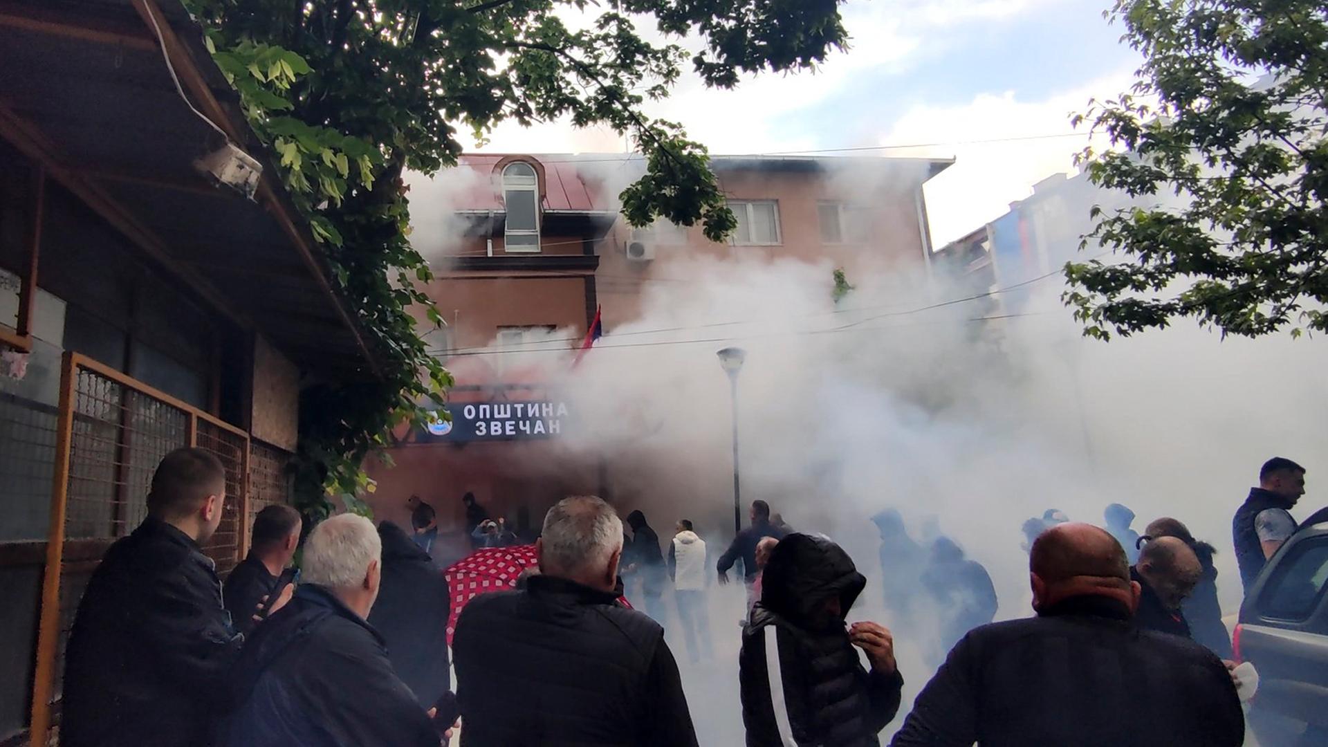 In diesem Bild aus einem Video wird Tränengas auf ethnische Serben vor einem Gemeindegebäude in Zvecan im nördlichen Kosovo abgefeuert. In diesem Bild aus einem Video wird Tränengas auf ethnische Serben vor einem Gemeindegebäude in Zvecan im nördlichen Kosovo abgefeuert.