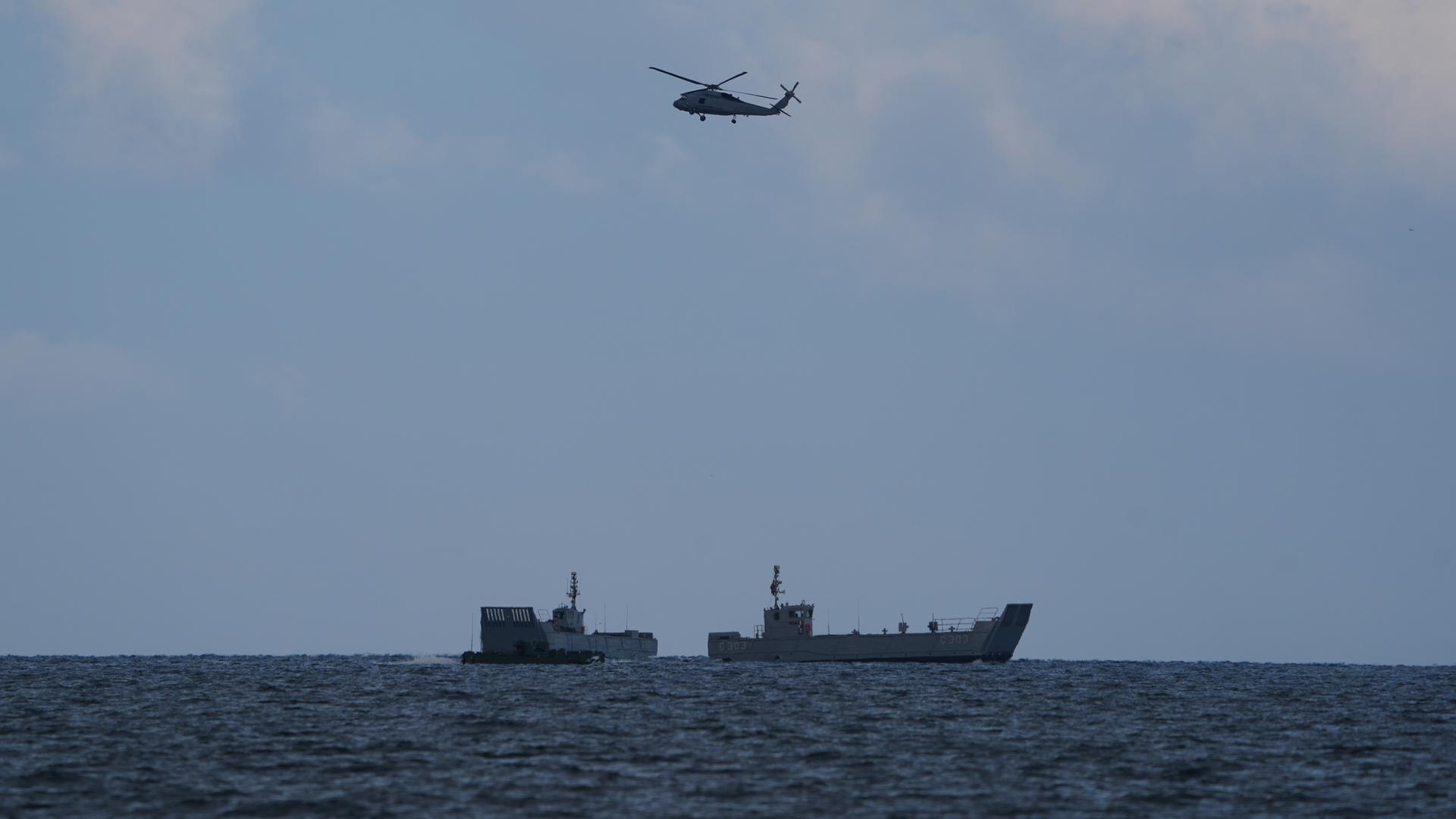  Ein Hubschrauber fliegt über Anlandungsboote während des Nato-Manövers Steadfast Dart auf dem Truppenübungsplatz an der Ostseeküste. 