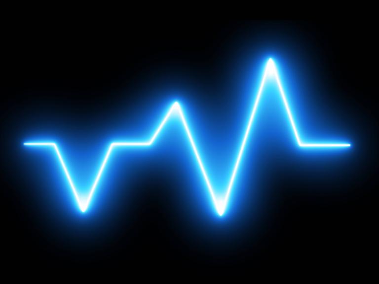 Grafik eines EKGs, die einen blauen Herzschlag vor schwarzem Hintergrund zeigt.