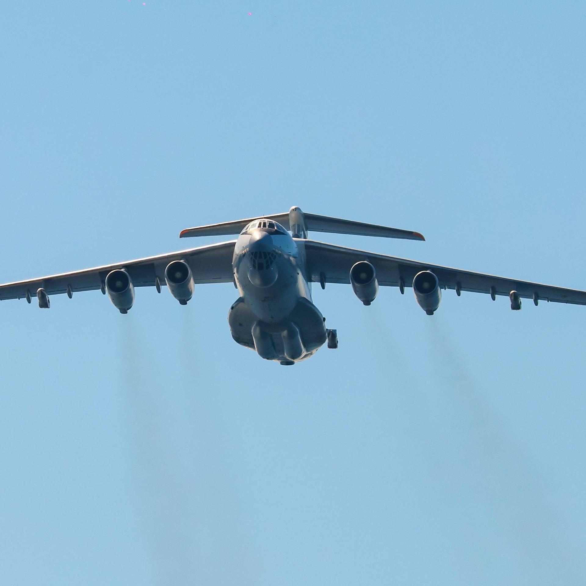 Das Bild zeigt eine große Militärmaschine am Himmel. Aus den insgesamt vier Düsen strömen dunkle Abgase. Das Bild zeigt eine große Militärmaschine am Himmel. Aus den insgesamt vier Düsen strömen dunkle Abgase.