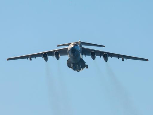 Das Bild zeigt eine große Militärmaschine am Himmel. Aus den insgesamt vier Düsen strömen dunkle Abgase. Das Bild zeigt eine große Militärmaschine am Himmel. Aus den insgesamt vier Düsen strömen dunkle Abgase.