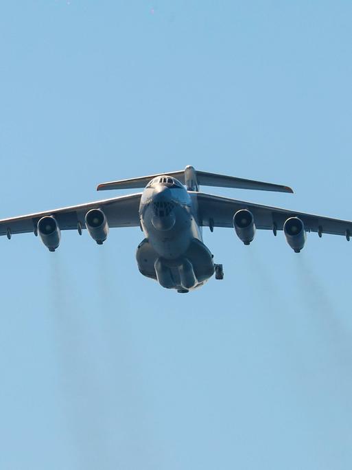 Das Bild zeigt eine große Militärmaschine am Himmel. Aus den insgesamt vier Düsen strömen dunkle Abgase. Das Bild zeigt eine große Militärmaschine am Himmel. Aus den insgesamt vier Düsen strömen dunkle Abgase.