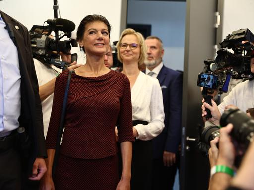 Am Wahltag in Thüringen kommen Sahra Wagenknecht, Katja Wolf und Steffen Schütz gemeinsam in einen Raum, in dem Kameraleute warten. Wagenknecht betritt den Raum zuerst, dahinter folgen Katja Wolf und Steffen Schütz.