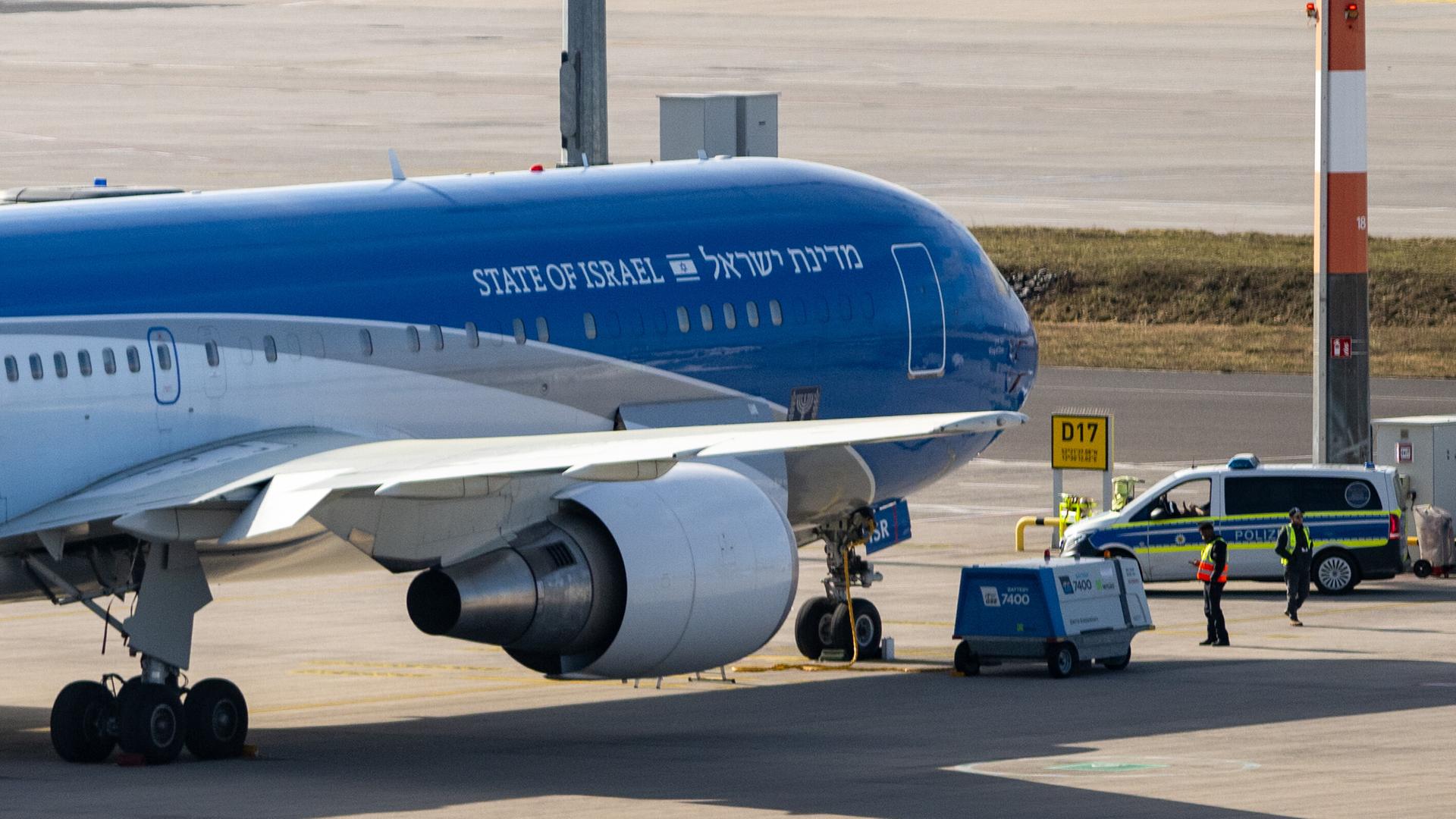 Ein blau-weißes Flugzeug mit der Aufschrift "State of Israel" steht auf einem Rollfeld, auch ein Schriftzug in Hebräisch ist aufgedruckt.