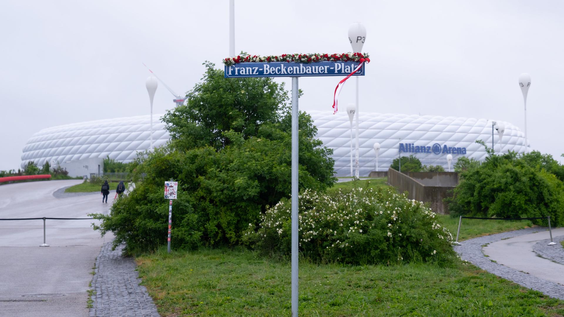 Ein Schild mit der Aufschrift "Franz-Beckenbauer-Platz" steht vor der Allianz Arena in München. Ein Schild mit der Aufschrift "Franz-Beckenbauer-Platz" steht vor der Allianz Arena in München.