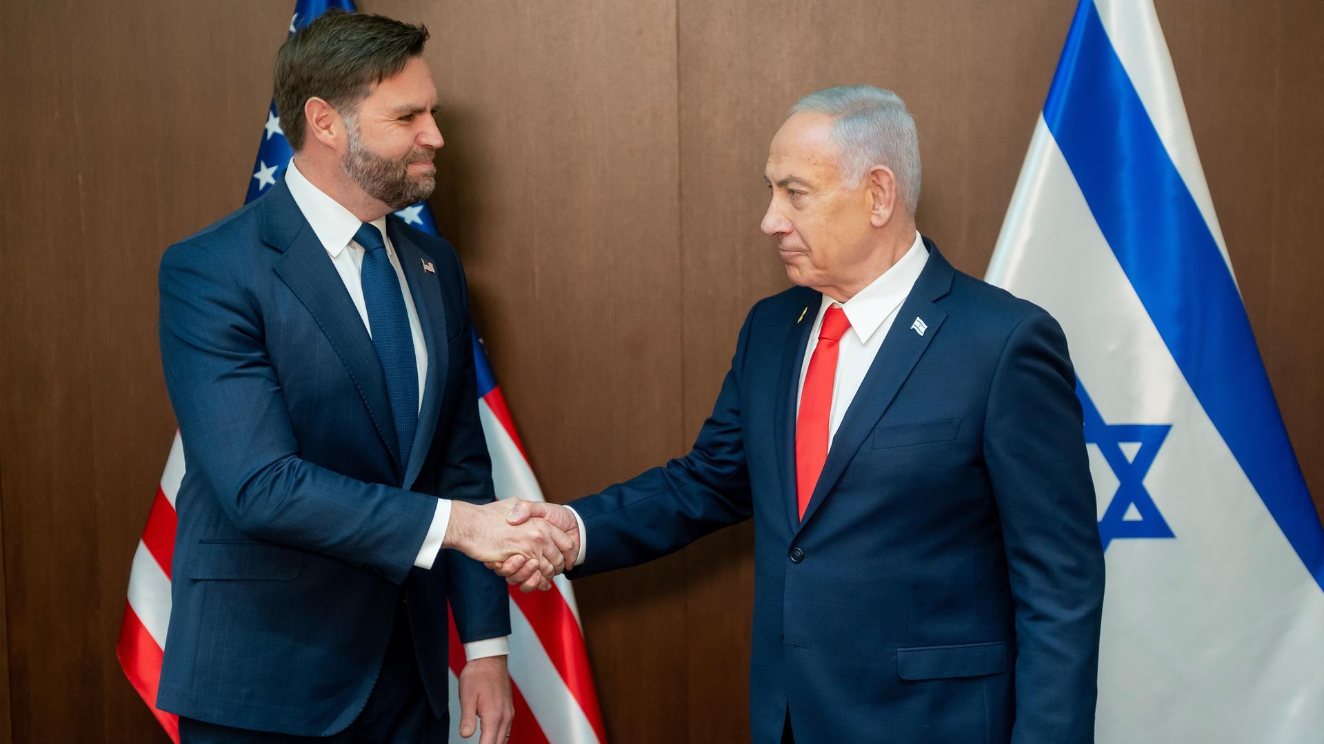 US-Vizepräsident Vance und der israelische Premierminister Netanjahu reichen sich die Hände. Hinter ihnen die Landesflaggen. US-Vizepräsident Vance und der israelische Premierminister Netanjahu reichen sich die Hände. Hinter ihnen die Landesflaggen.