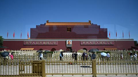 Peking: Menschen laufen vor dem von einem Baugerüst umringten Himmelstor mit dem Konterfei Mao Zedongs am Platz des Himmlischen Friedens (Tiananmen) vorbei.