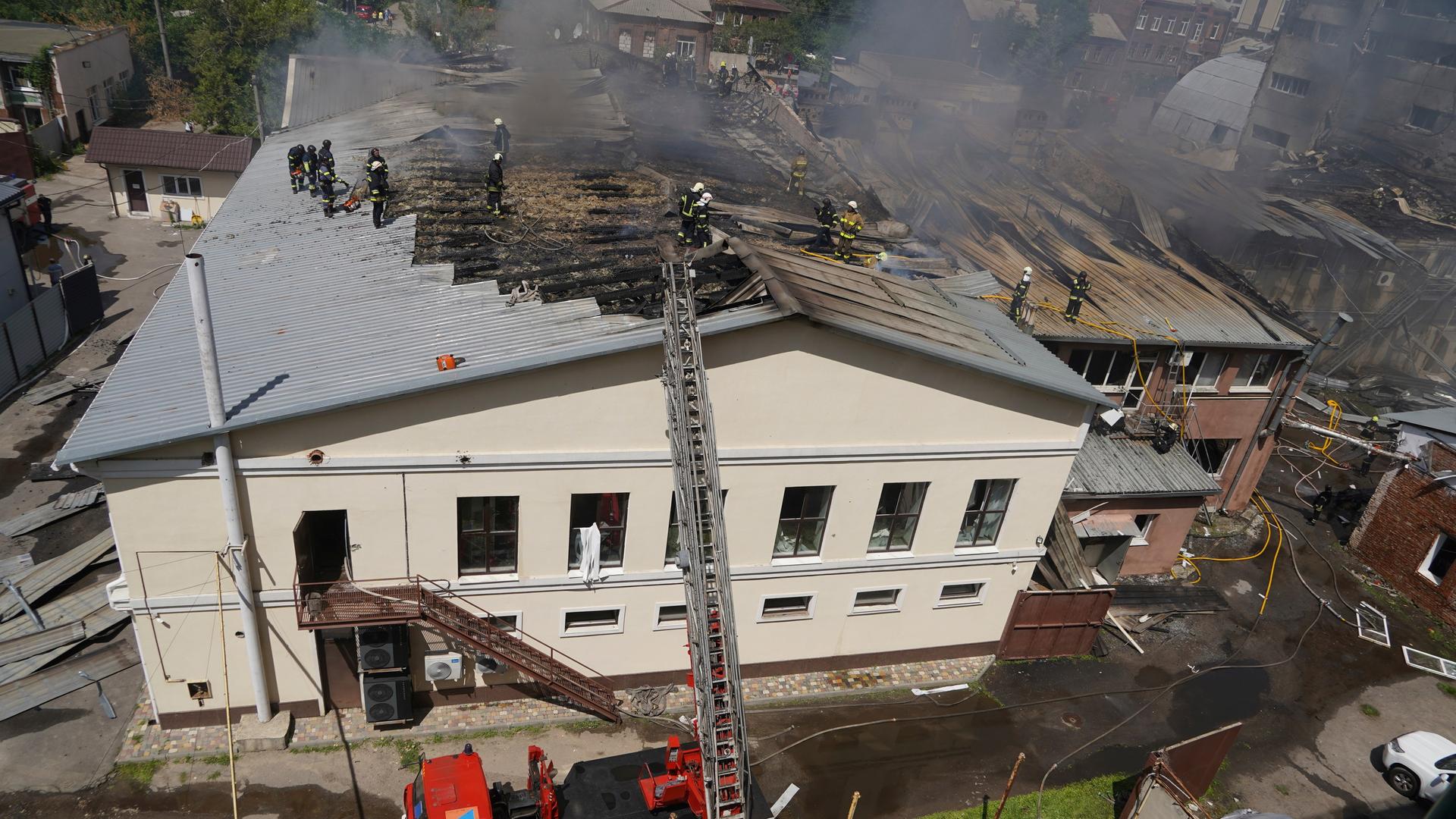 Feuerwehrleute bekämpfen den Brand nach einem russischen Angriff auf ein Wohngebiet in Charkiw, Ukraine. 