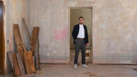 Der Autor und Schriftsteller Lukas Rietzschel steht in seinem Wohnort Görlitz in einer unrenovierten Altbauwohnung, 2021.