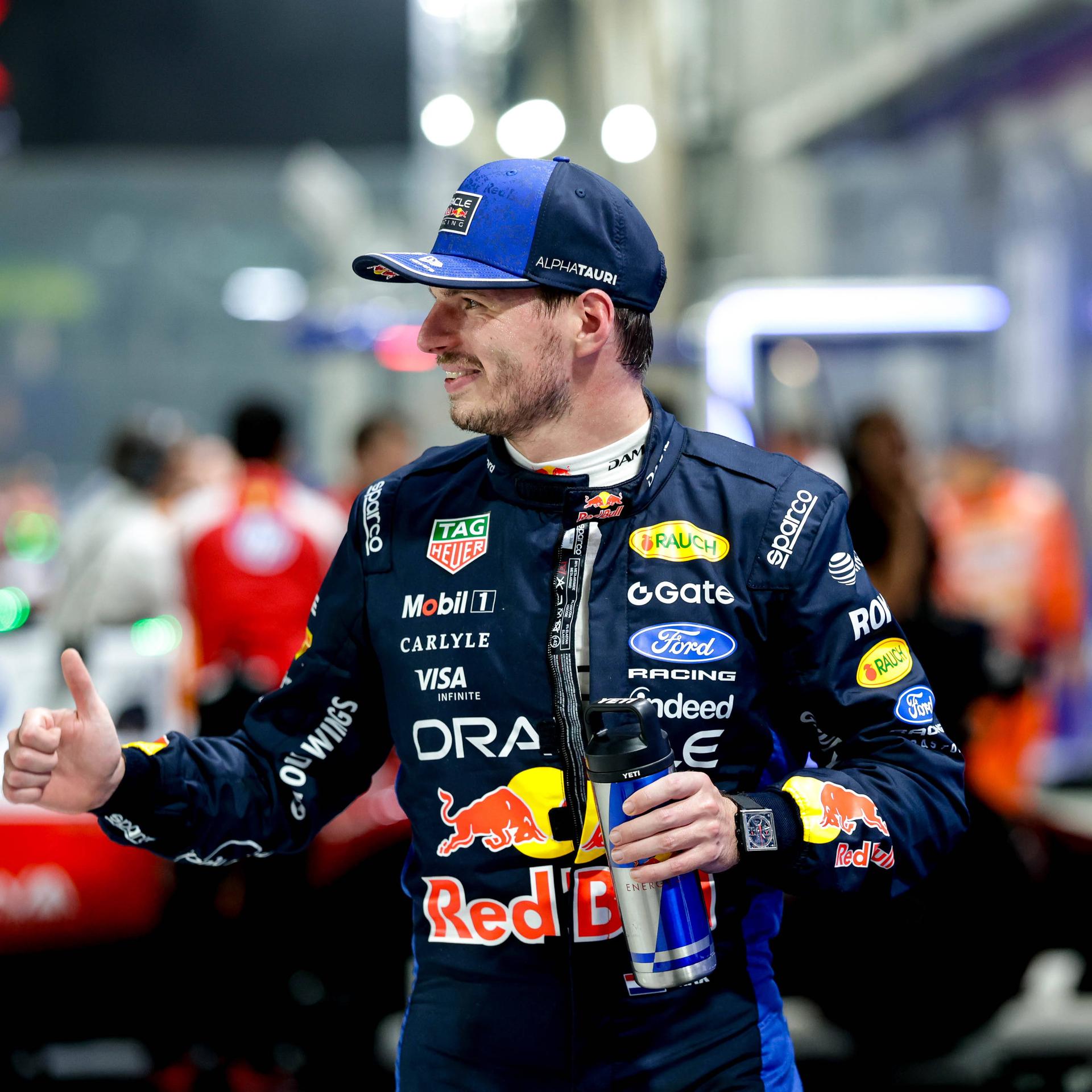 Max Verstappen gewinnt den Großen Preis von Singapur. Er steht an der Rennstrecke, lächelt und hält die rechte Hand mit dem Daumen nach oben.

